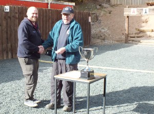 Jonny is presented with the JSPC Gallery Rifle Spring Trophy, and Colin seems to be having a good laugh as well.